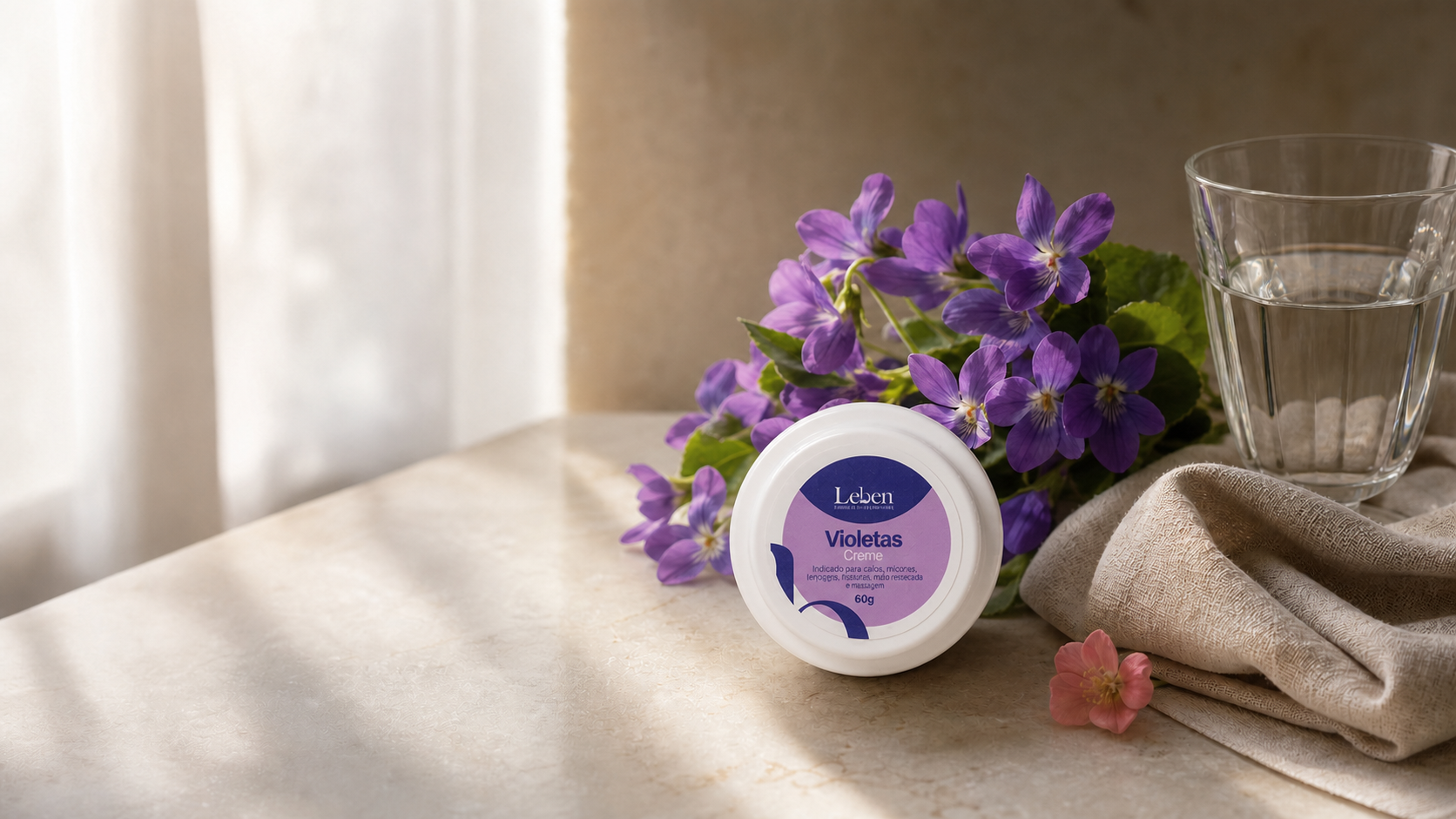 Bouquet de violetas roxas ao lado de tigela branca com creme cosmético, sobre bancada de mármore claro iluminada por luz natural